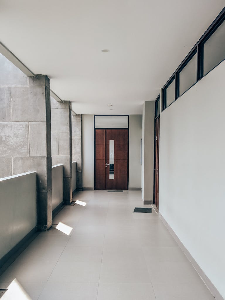 Bright and clean modern hallway in a minimalist apartment, capturing sunlight and shadows.